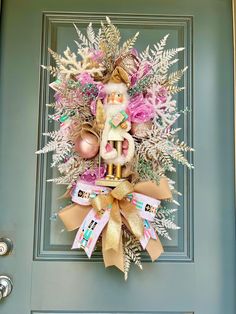 a christmas wreath on the front door decorated with pink, gold and white ornaments is displayed