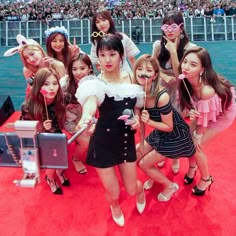 the girls are posing on the red carpet with their cell phones in front of them