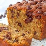 a close up of a loaf of bread on a table with chocolate chips around it