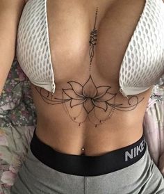 a woman's stomach with a tattoo on her belly and the bottom part of her bra