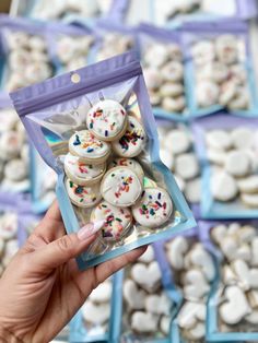 a hand holding up a bag of white and sprinkle covered cookies