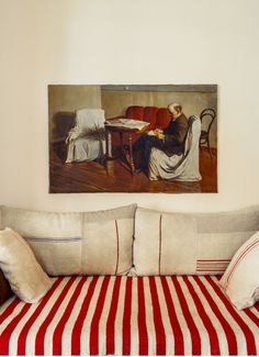 a couch that is in front of a wall with a painting on the wall above it