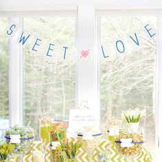 a table topped with lots of candy and candies next to a window filled with windows