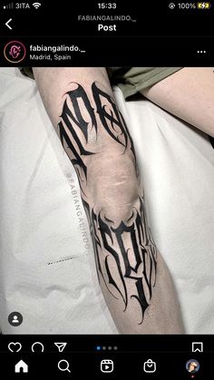 a man's arm with black ink on it and the word tattoo written in cursive font