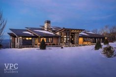 this is an image of a luxury home in the snow at night with lights on