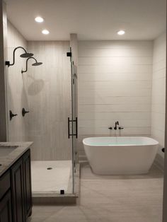 a white bath tub sitting inside of a bathroom next to a walk in shower stall