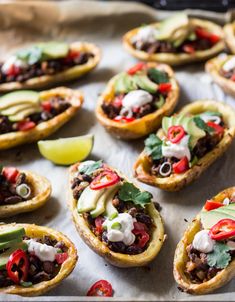 an assortment of taco shells with toppings on a baking sheet, ready to be eaten