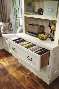 a white cabinet with drawers filled with books