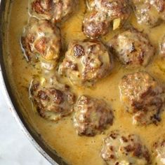 meatballs and gravy are cooking in a pot