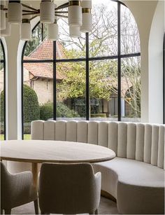 a table and chairs in front of large windows