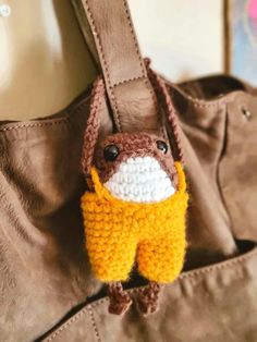 a crocheted bag with a stuffed animal hanging from it's front pocket