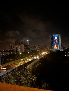 the city skyline is lit up at night with bright lights and buildings in the background