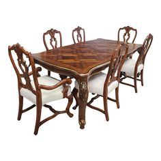 a dining room table and chairs with white upholstered cushions on the backrests