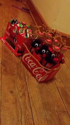 an open coca - cola box on the floor with six cans in it and eyes