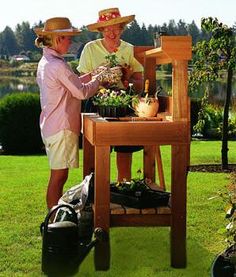 two people standing next to each other in front of a table with flowers and plants on it