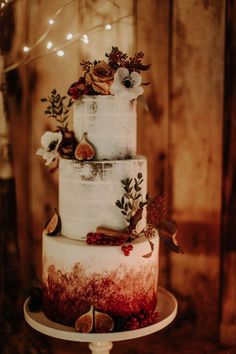 a three tiered cake with white frosting and flowers