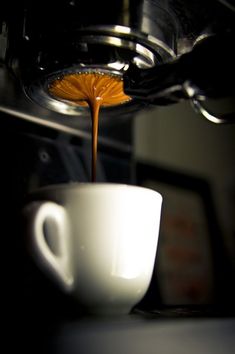 coffee being poured into a white cup