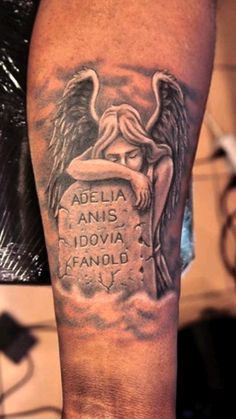 a man's arm with an angel and inscription on the back of his leg