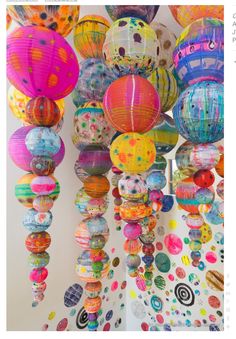 many colorful paper lanterns hanging from the ceiling