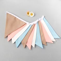 a bunch of different colored paper flags on top of a gray table next to a flower