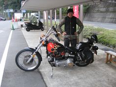 a man standing next to a parked motorcycle