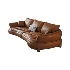 a brown leather couch sitting on top of a white floor next to a pillow covered chair