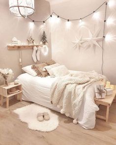 a bedroom decorated in white with starfish decorations on the wall and lights strung from the ceiling