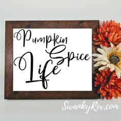 a sign that says pumpkin spice life with flowers on the wall next to it and a wooden frame