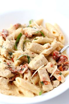 a white bowl filled with pasta and meat