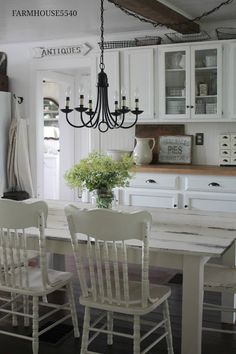 a dining room table with chairs and a chandelier hanging from it's ceiling