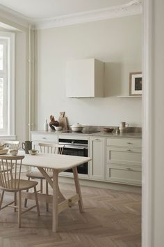 the kitchen is clean and ready to be used for dinner or lunchtime, with all white furniture