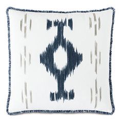 a blue and white pillow with fringes on the bottom, in front of a white background