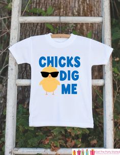 a white t - shirt with the words chicks dig me on it hanging from a ladder