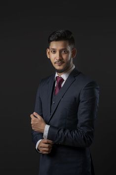 a man in a suit and tie standing with his arms crossed