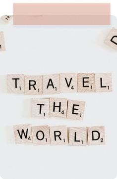 travel the world spelled with scrabbles on a white board and pink border