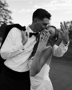 a man and woman kissing each other in black and white