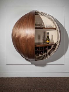 a wine rack with bottles and glasses on it in front of a wall mounted mirror