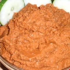 a bowl filled with carrots and cucumbers on top of a table