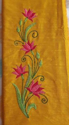 an embroidered yellow cloth with pink flowers on it