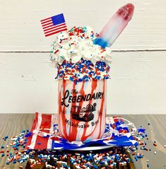 an ice cream sundae with sprinkles and american flag decorations on it