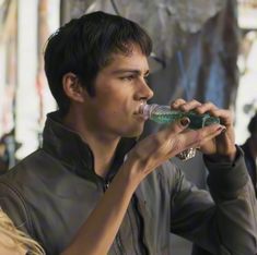 a young man drinking from a plastic bottle