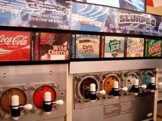 a row of soda machines sitting next to each other