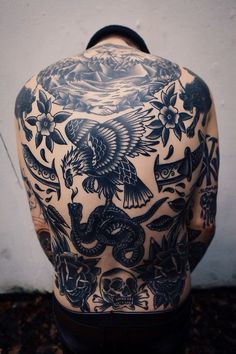 the back of a man's body with tattoos on it