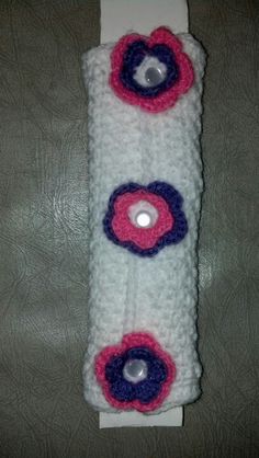 a white crocheted object with pink and blue flowers on it's side