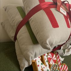 two decorative pillows with ribbons tied around them on the floor next to gingerbreads