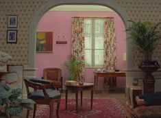 a living room filled with furniture and pink walls