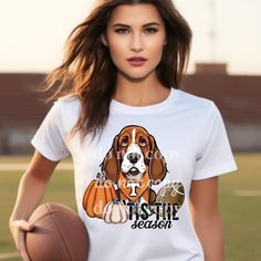 a woman holding a basketball and wearing a t - shirt with a dog on it