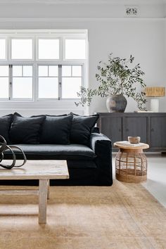 a living room filled with furniture and a wooden coffee table in front of a window