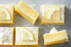 lemon bars with powdered sugar are arranged on a baking sheet, ready to be cut into wedges