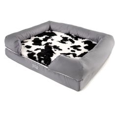 a dog bed with a cow print pattern on the front and back, in grey